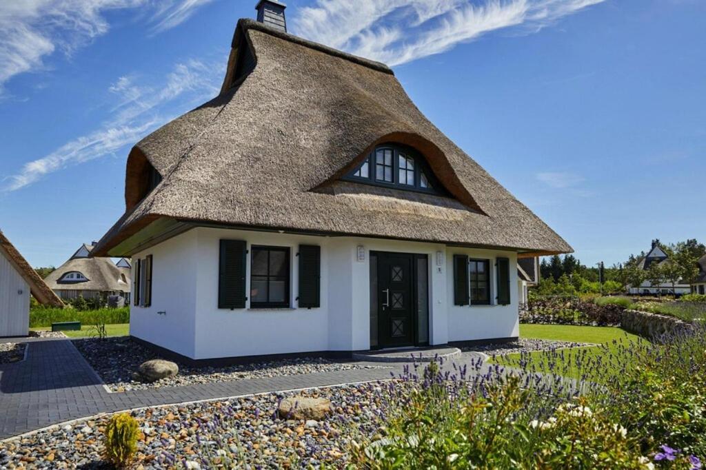 a thatched cottage with a thatched roof at Holiday house, Fuhlendorf in Fuhlendorf