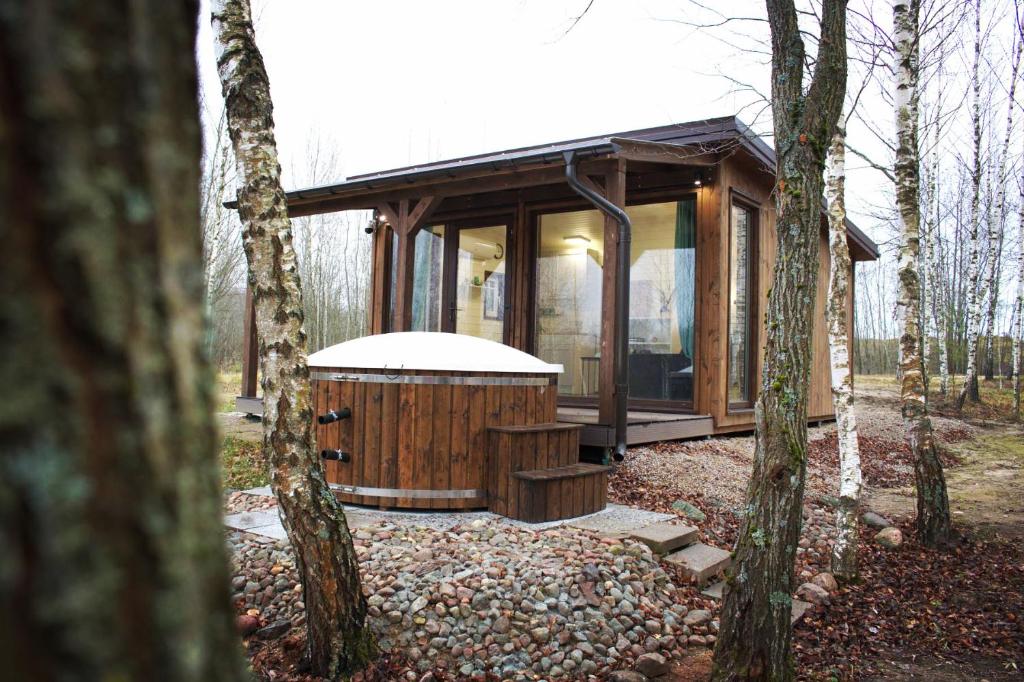 une cabane en bois avec un bain à remous dans les bois dans l'établissement Riešutynė, à Gražuliai
