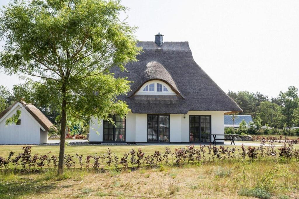 a large white house with a thatched roof at Holiday house, Fuhlendorf in Fuhlendorf