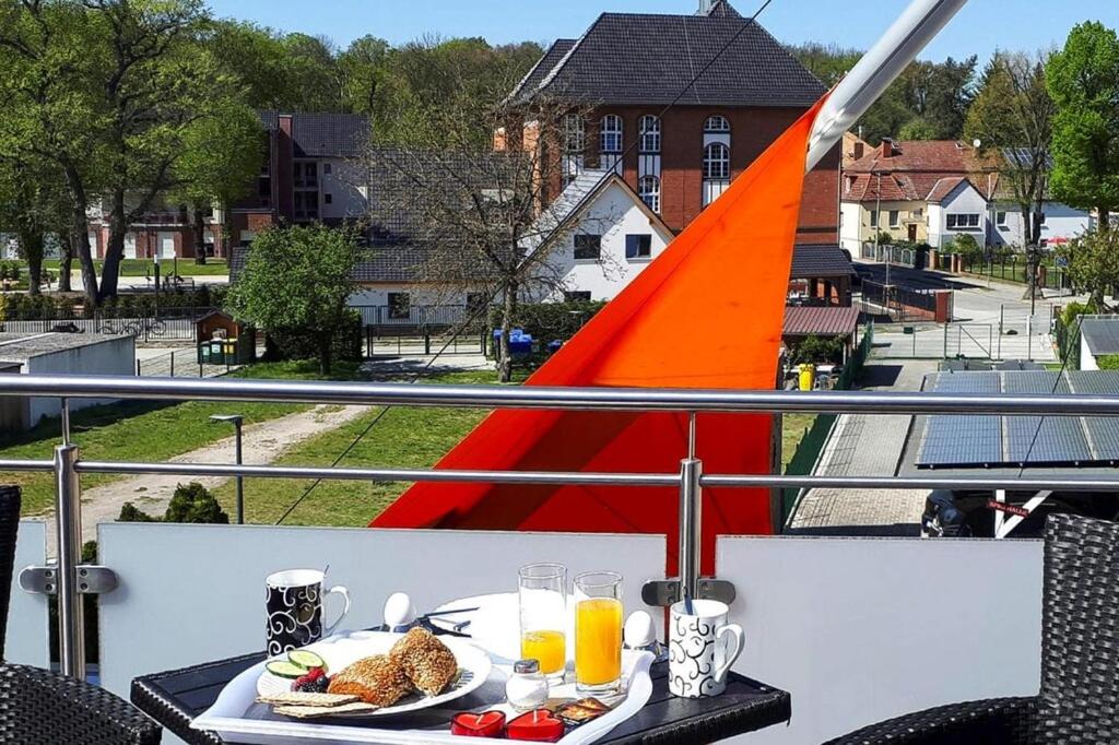 a table with a plate of food on a balcony at Apartment SL Lounge, Luebben in Lübben