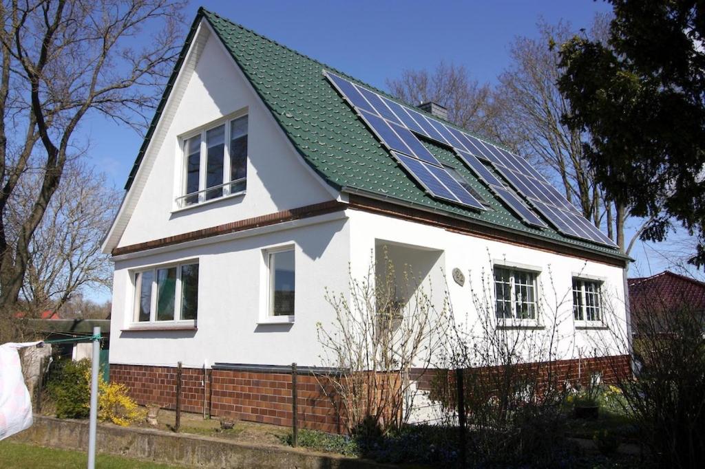 a white house with solar panels on the roof at Gemütliche Ferienwohnung in Mallentin in Mallentin