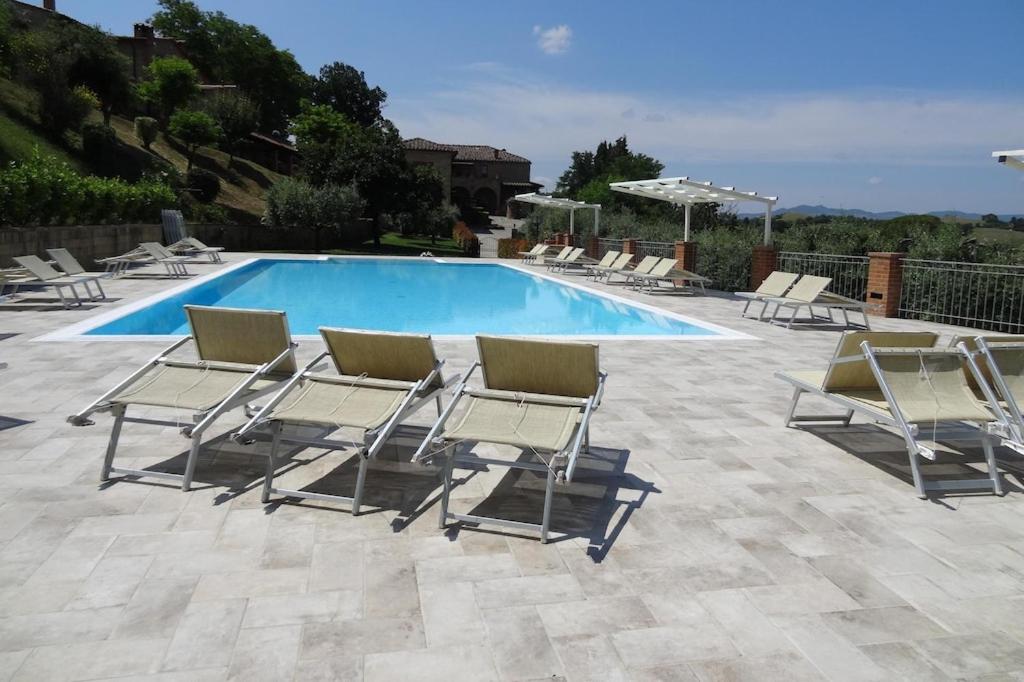 沃爾泰拉的住宿－Farmhouse stay Giulia Volterra，一组躺椅和一个游泳池