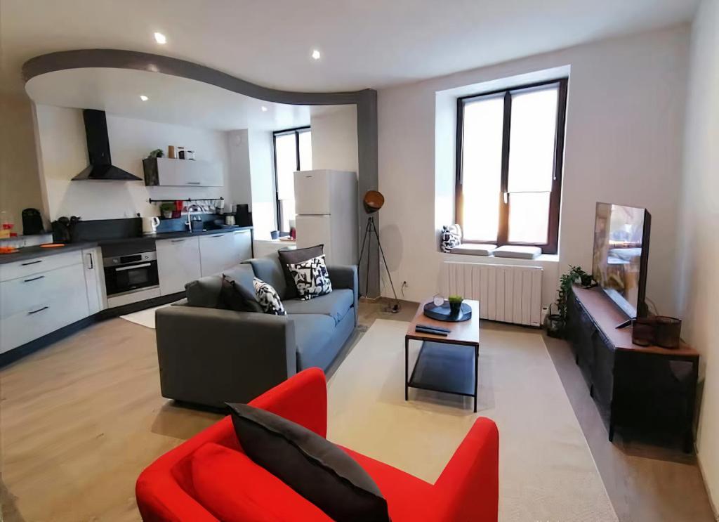 a living room with a couch and a red chair at Grand Appartement 2 chambres avec Fibre et Netflix in Belfort