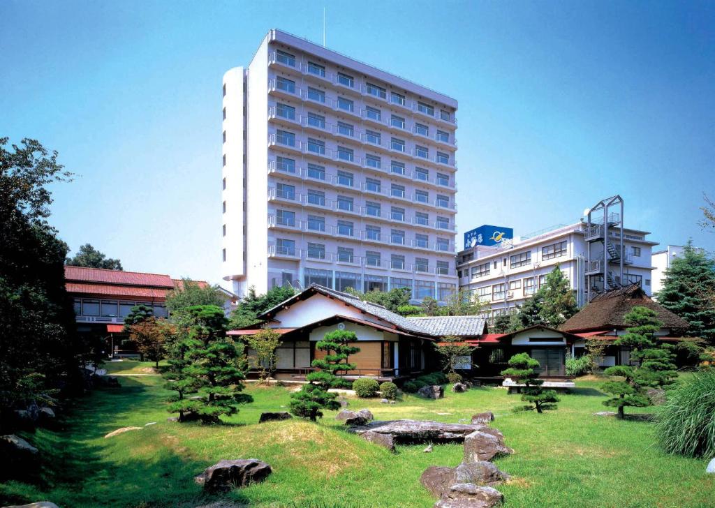 a large building with a garden in front of a building at Hotel Parens Onoya in Asakura