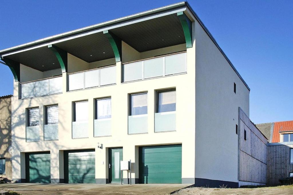 a large white building with green garage doors at Apartment lake view, Malchow in Malchow