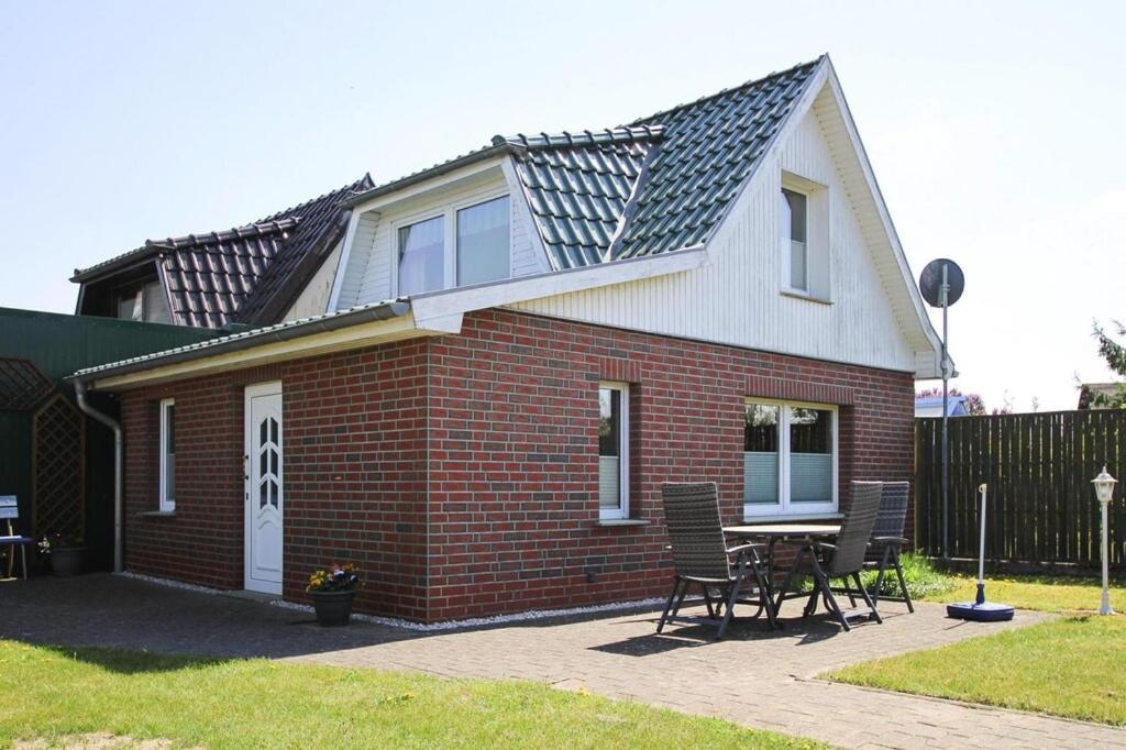 ein kleines Backsteinhaus mit einem Tisch und Stühlen in der Unterkunft Holiday home, Plau am See in Plau am See