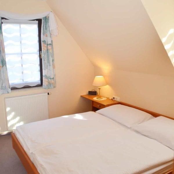 a small bedroom with a bed and a window at Apartmenthaus Spreewaldperle in Burg