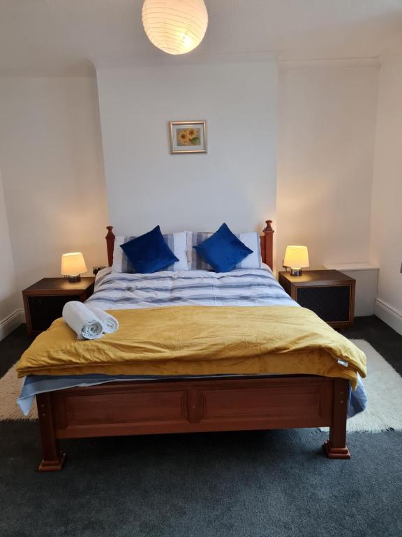 a bedroom with a large bed with blue pillows at Entire Premium Holiday Cottage in Monkwearmouth