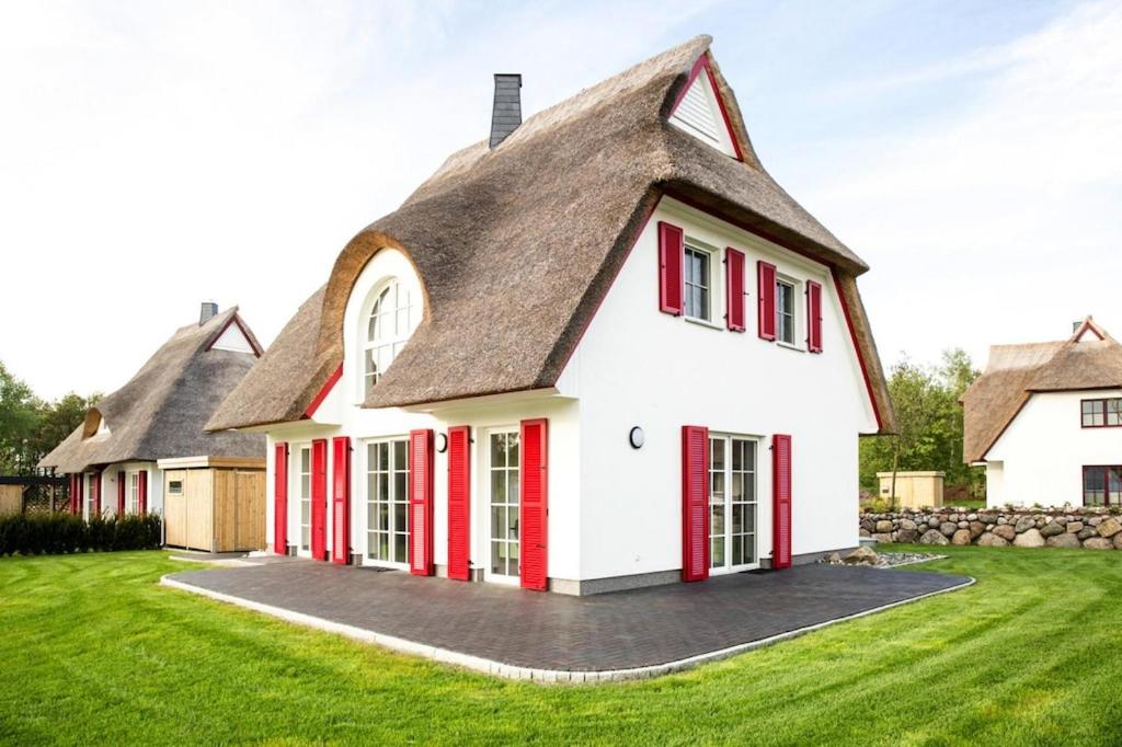 a large white house with a thatched roof at Holiday house, Fuhlendorf in Fuhlendorf