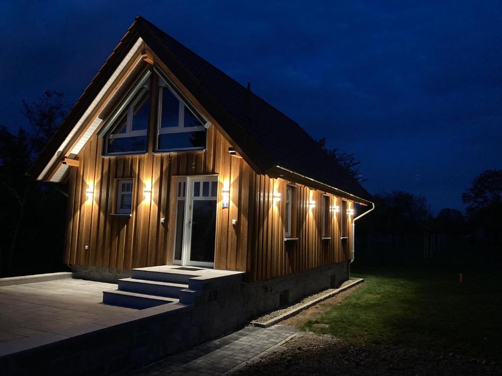 a wooden house with lights on it at night at Ferienhaus im Obstgarten in Darlingerode