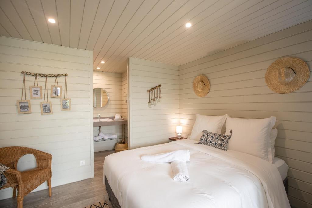 1 dormitorio con 1 cama blanca grande y 1 silla en Blue Sail Hotel en Anse Marcel 