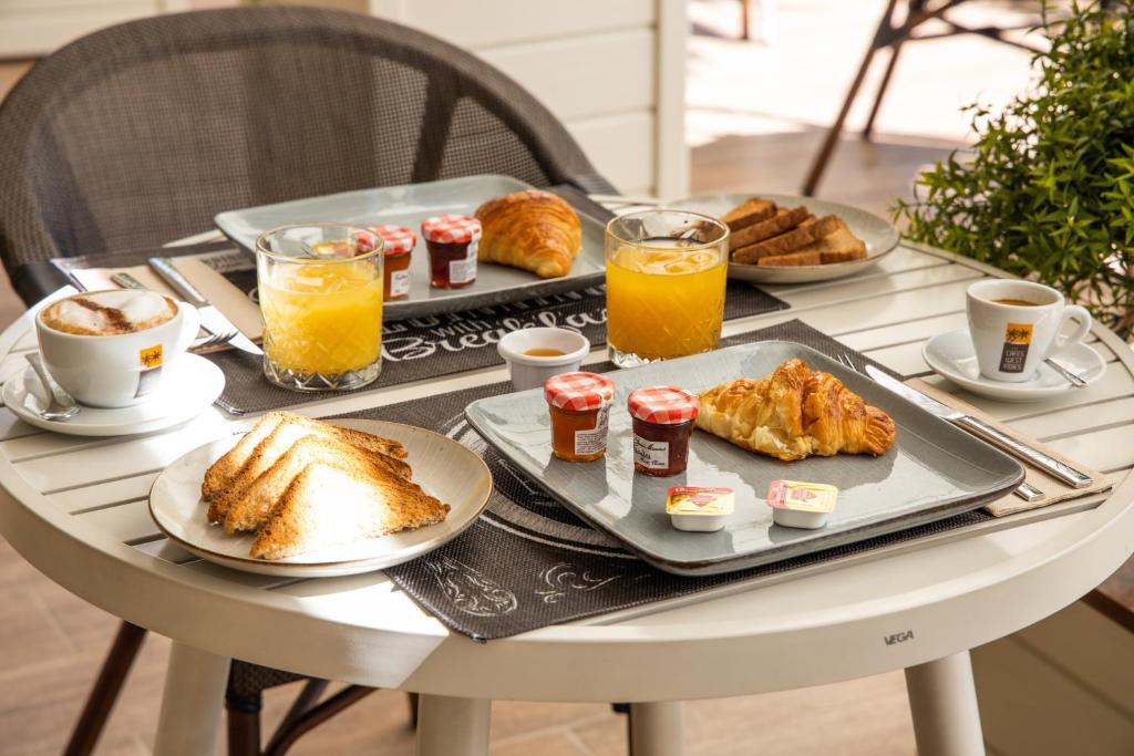 a table with breakfast foods and drinks on it at Blue Sail Hotel in Anse Marcel 