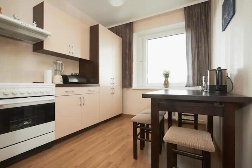 a kitchen with a table and chairs and a window at Nice private room in a three room apartment Free parking Feel like at home in Vilnius
