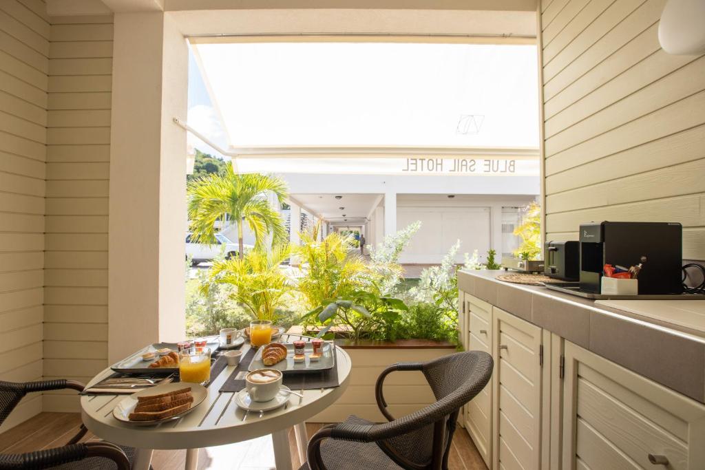 a breakfast table in a kitchen with a large window at Blue Sail Hotel in Anse Marcel 