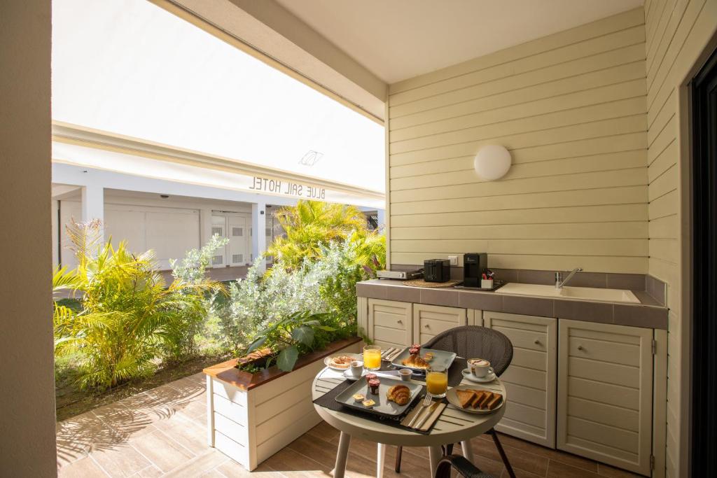 a patio with a table and chairs and a kitchen at Blue Sail Hotel in Anse Marcel 