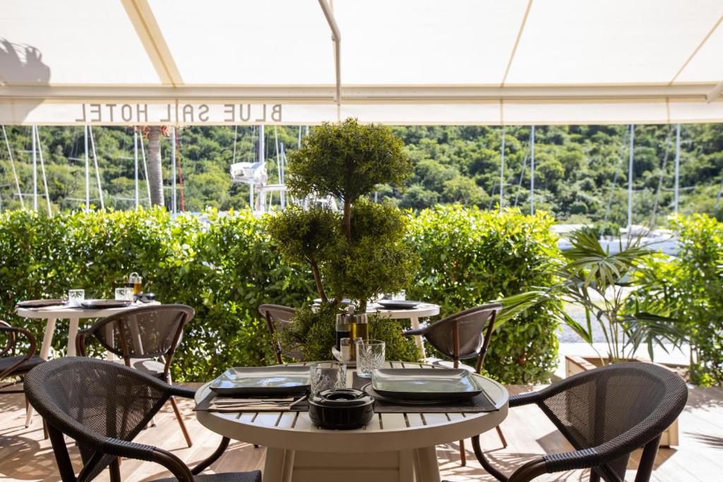 a table and chairs in a room with a large window at Blue Sail Hotel in Anse Marcel 
