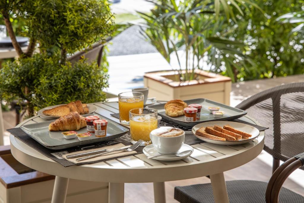 a table with breakfast foods and drinks on it at Blue Sail Hotel in Anse Marcel 