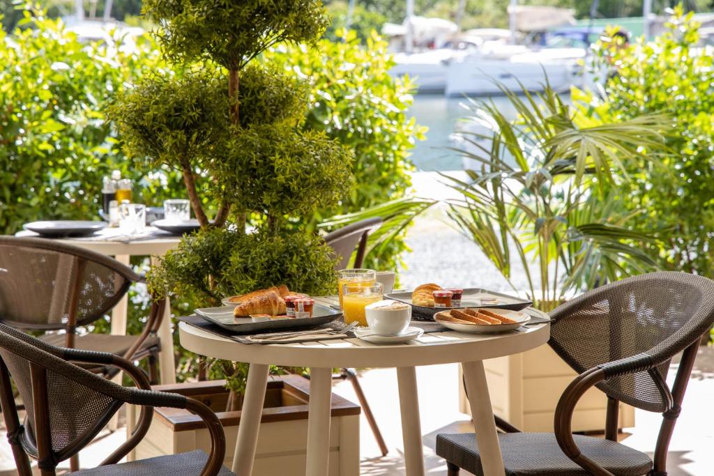 a table with breakfast foods and drinks on a patio at Blue Sail Hotel in Anse Marcel 