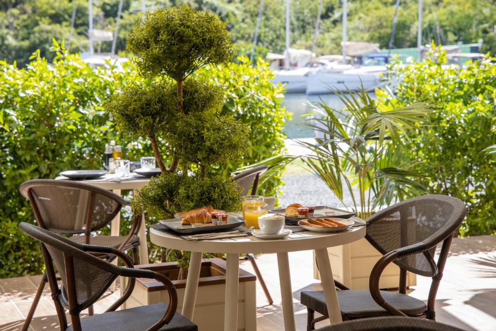 a table with food and drinks on a patio at Blue Sail Hotel in Anse Marcel 