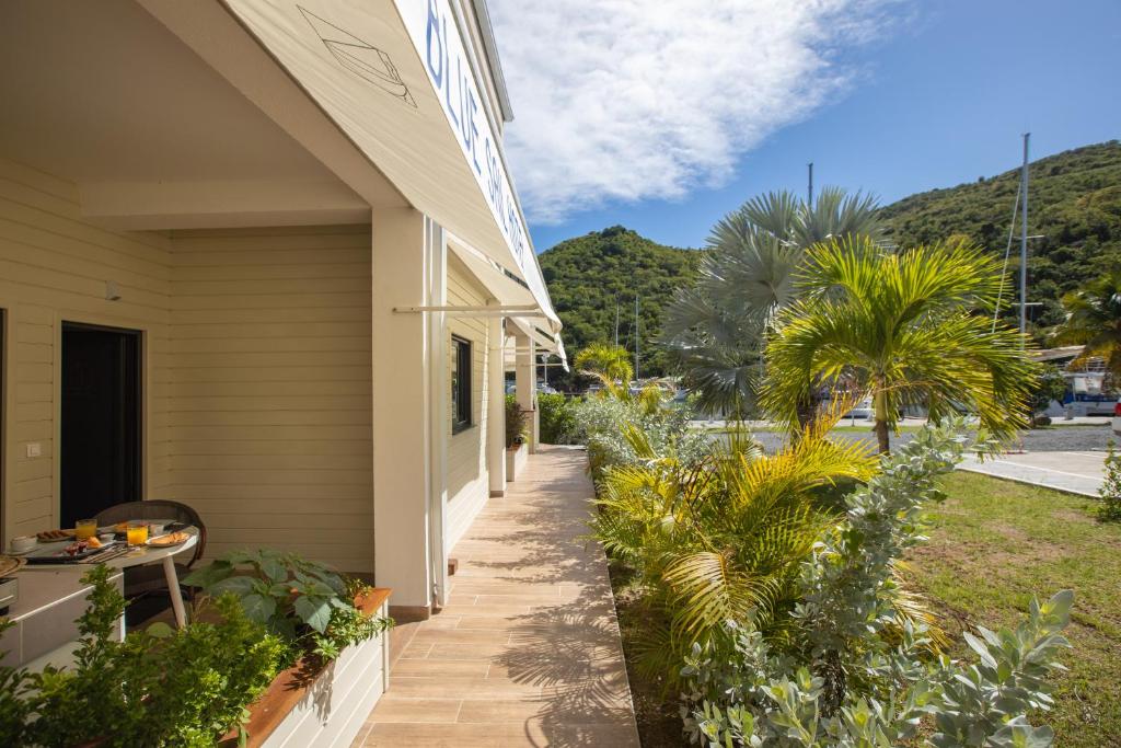 a porch of a house with plants and trees at Blue Sail Hotel in Anse Marcel 