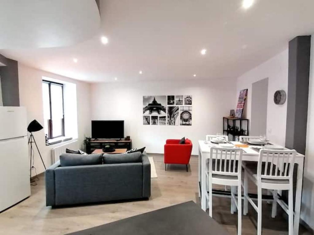 a living room with a couch and a table at Grand Appartement 2 chambres avec Fibre et Netflix in Belfort