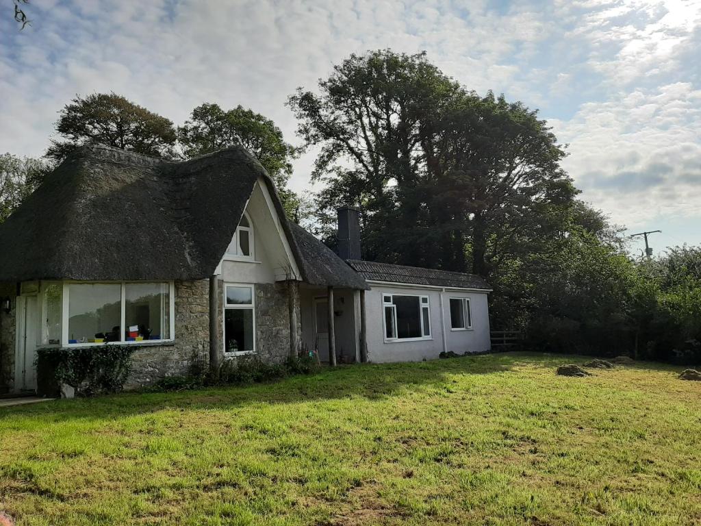 an old house with a thatched roof on a yard at Quintessential, secluded South Devon cottage in Plymouth