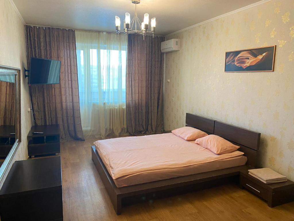 a bedroom with a bed and a large window at Apartments on Ryabikova in Ulyanovsk