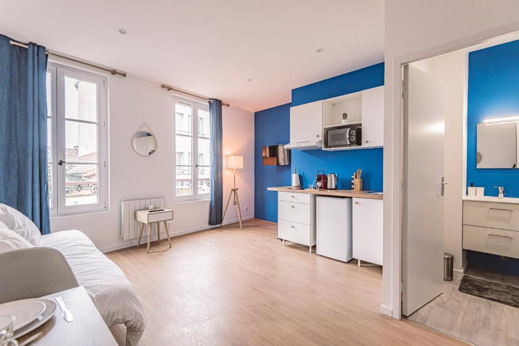 1 dormitorio con paredes azules y cocina con armarios blancos. en Plancy Beds Châlons en Châlons-en-Champagne