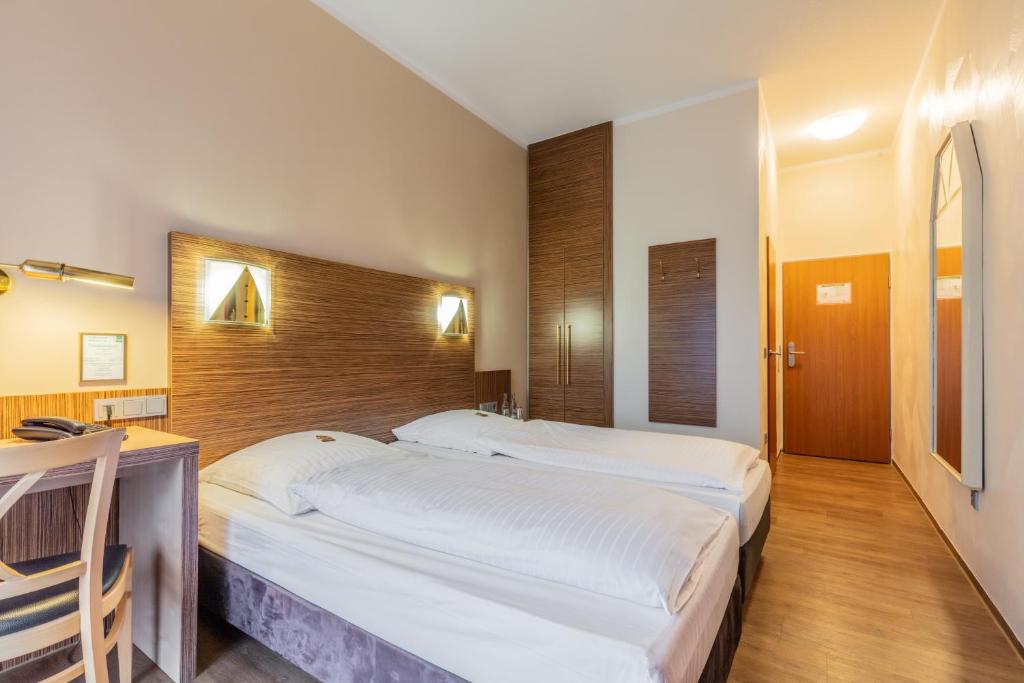 מיטה או מיטות בחדר ב-Sport- und Tagungshotel De Poort