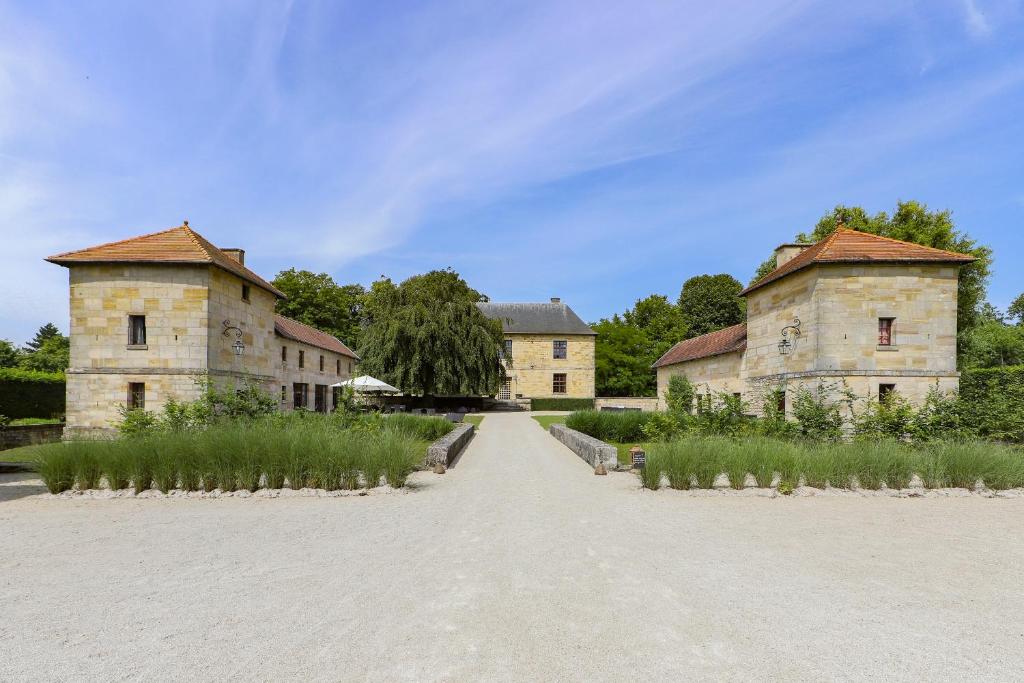 two old stone buildings on a dirt road at La Maison Forte in Revigny-sur-Ornain