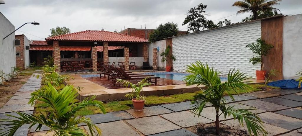 a house with a swimming pool in a yard at Pousada RIOSTOUR in Barreirinhas