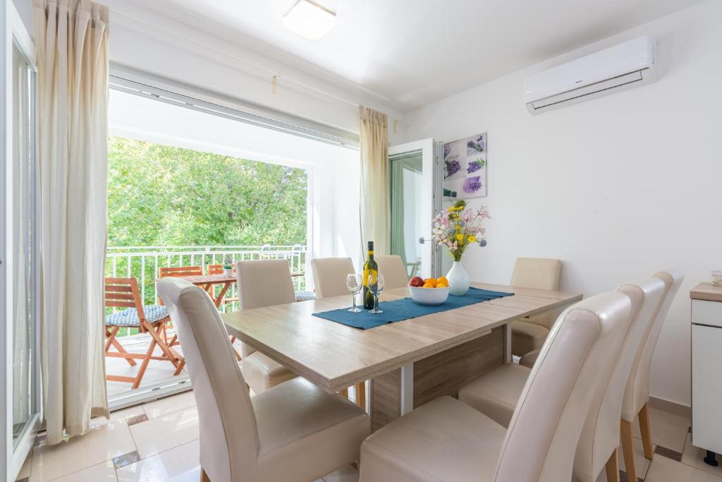 a dining room with a table and chairs and a window at Apartment Lovorka 5 in Baška
