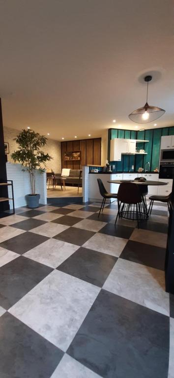 a room with a checkered floor with tables and chairs at EnTerrasse 4 étoiles in Dinan