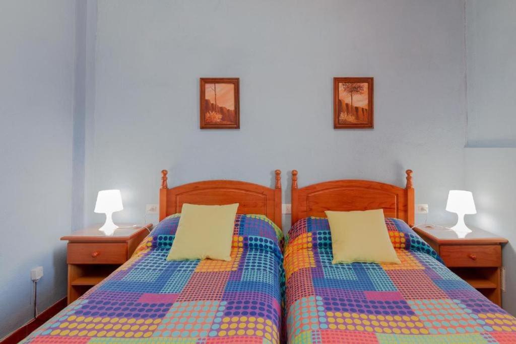 a bedroom with a bed with two night stands and two lamps at Catalino I in El Paso