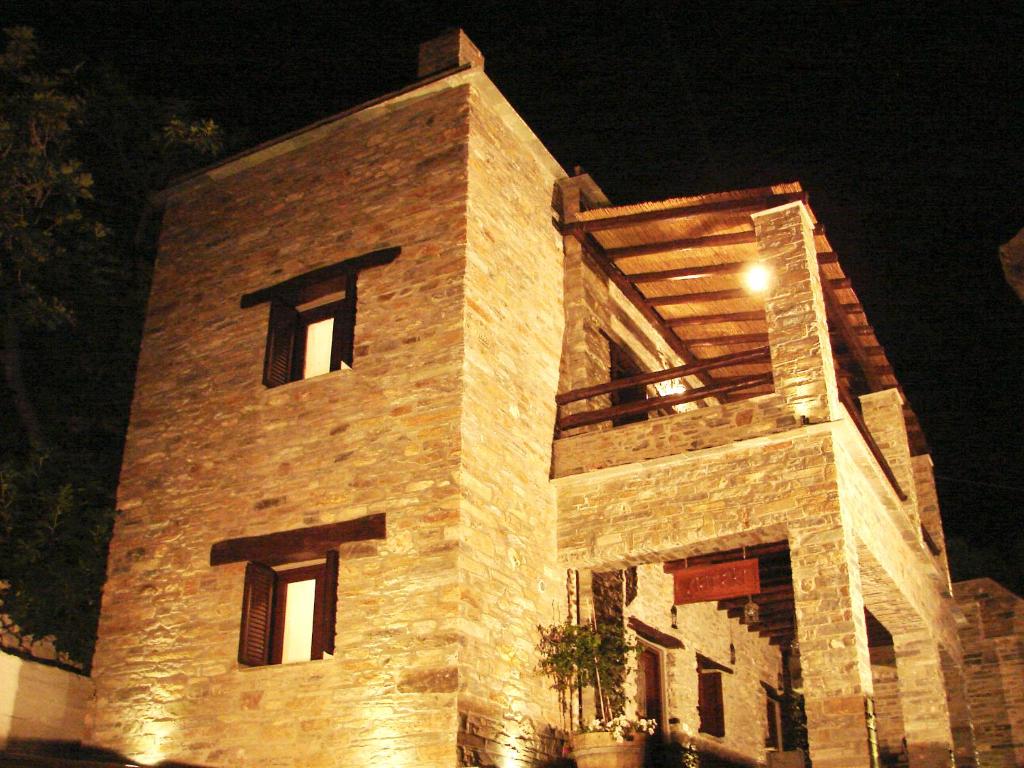 a tall brick building with lights on it at night at Giataki in Karistos