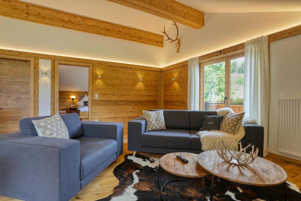 uma sala de estar com dois sofás azuis e uma mesa em Ferienwohnung Wolf em Fischen