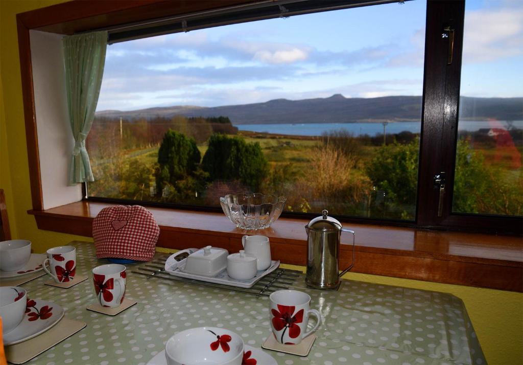 a table with a view of a large window at Bramble Cottage in Ollach