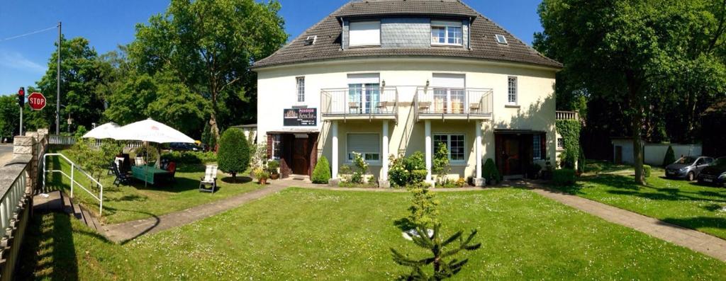 a large white house with a gambrel roof at Pension-Sendis in Herne