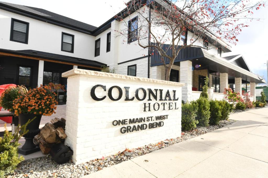 a sign for a colonial hotel in front of a building at Colonial Hotel & Suites in Grand Bend