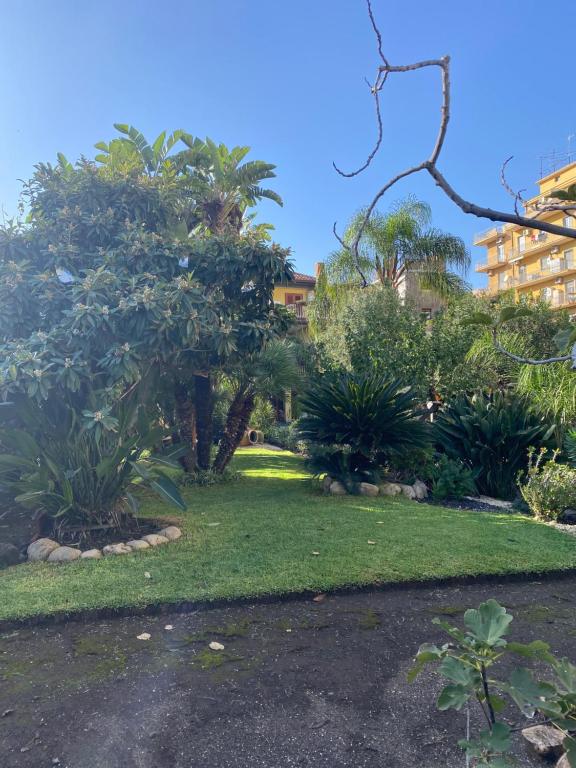 un parque con árboles y césped y un edificio en Casa delle Rose, en Catania