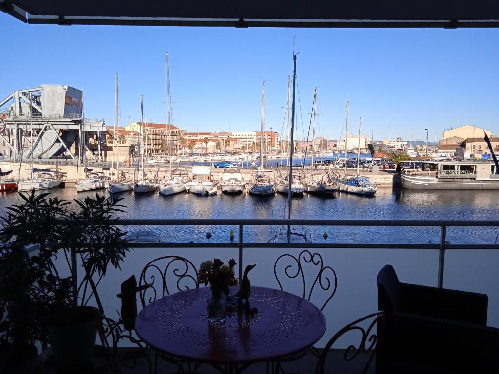 - une table sur un balcon avec vue sur le port de plaisance dans l'établissement Appartement Cosy Terrasse vue Quai Canal + parking, à Sète