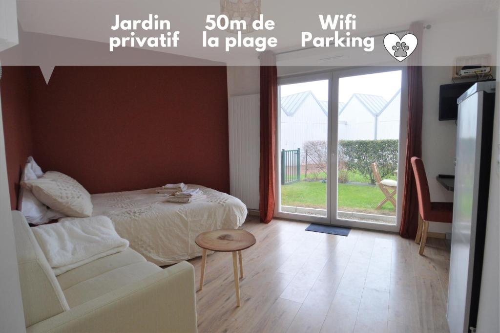 a bedroom with a bed and a couch and a window at Jardin - à 50m de la plage - Wifi - Parking in Courseulles-sur-Mer