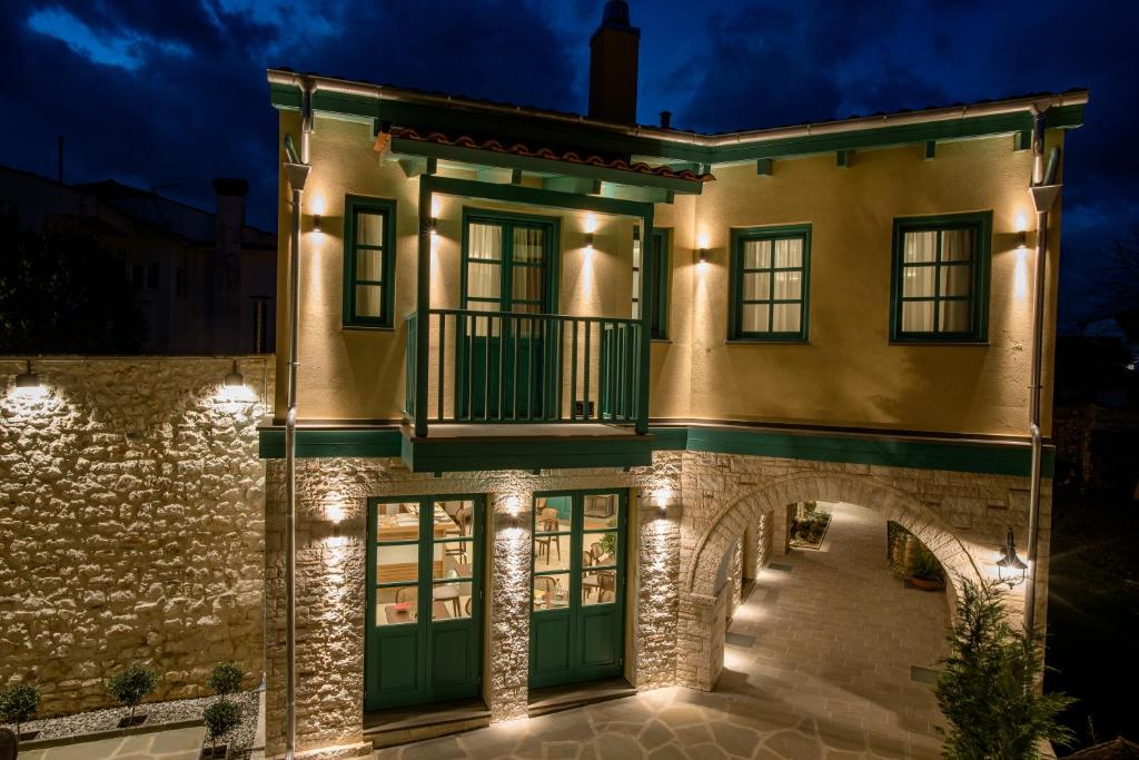 um edifício com uma varanda e luzes sobre ele em CASTRELLO Old Town Hospitality em Ioannina