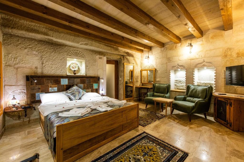 a bedroom with a bed and two chairs in a room at Charming Cave Hotel in Goreme