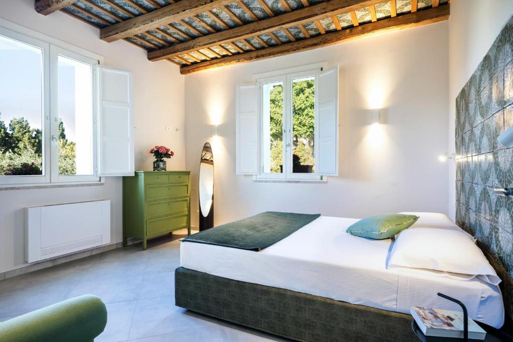 sypialnia z dużym łóżkiem i dwoma oknami w obiekcie Villa Angelina - charming rooms & apartments w Trapani