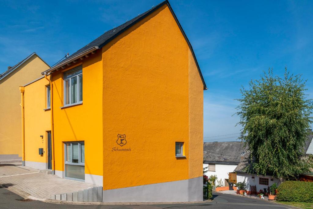 ein gelbes und orangefarbenes Gebäude auf einer Straße in der Unterkunft Schusters Haus in Boppard