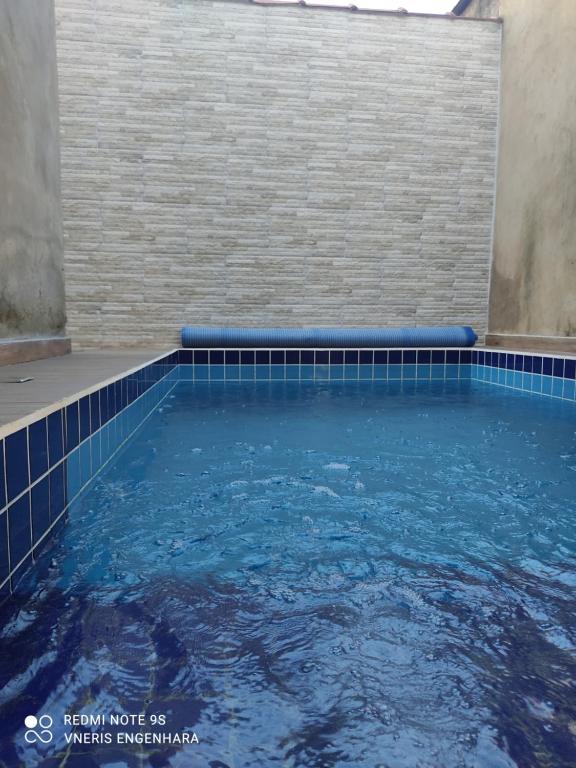 - une piscine avec un mur en carrelage et de l'eau bleue dans l'établissement Casa Neris, à Pirenópolis
