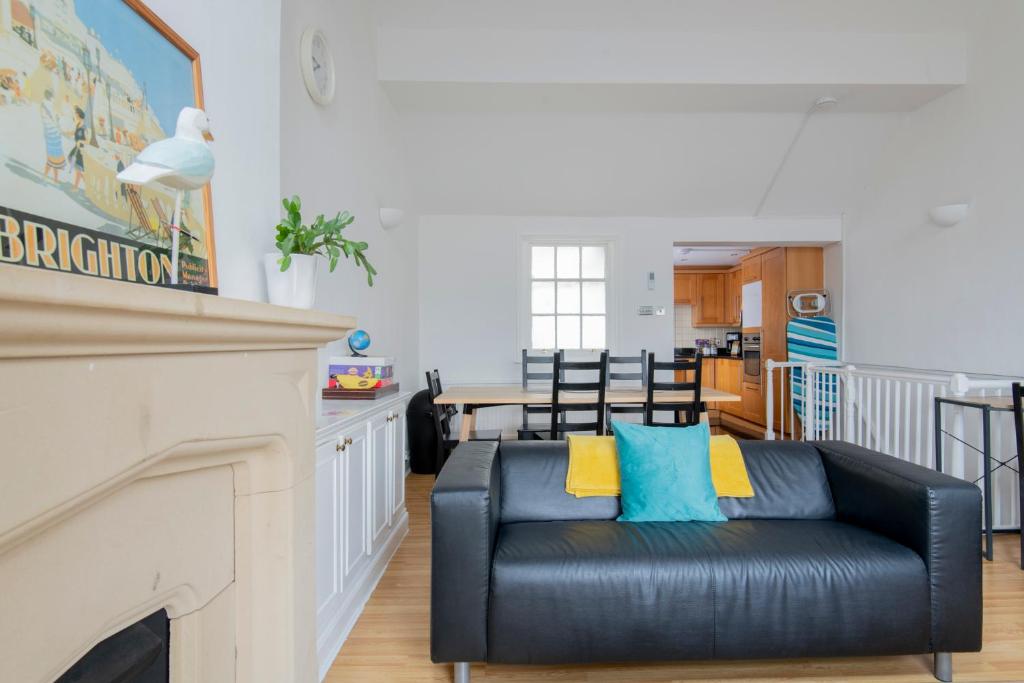 a living room with a black leather couch and a fireplace at Fantastic 3 Bed Brighton House- Sleeps 6- SUPERFAST WiFi and Garage in Brighton & Hove