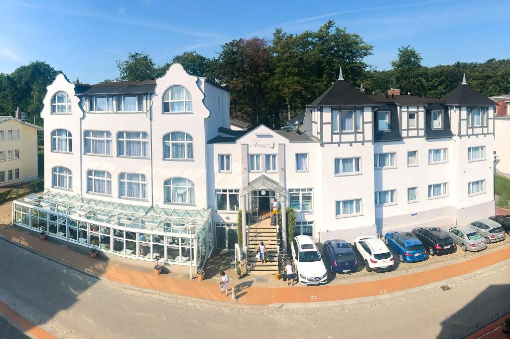 a large white building with cars parked in front of it at Villa Auszeit Hotel Garni in Bansin