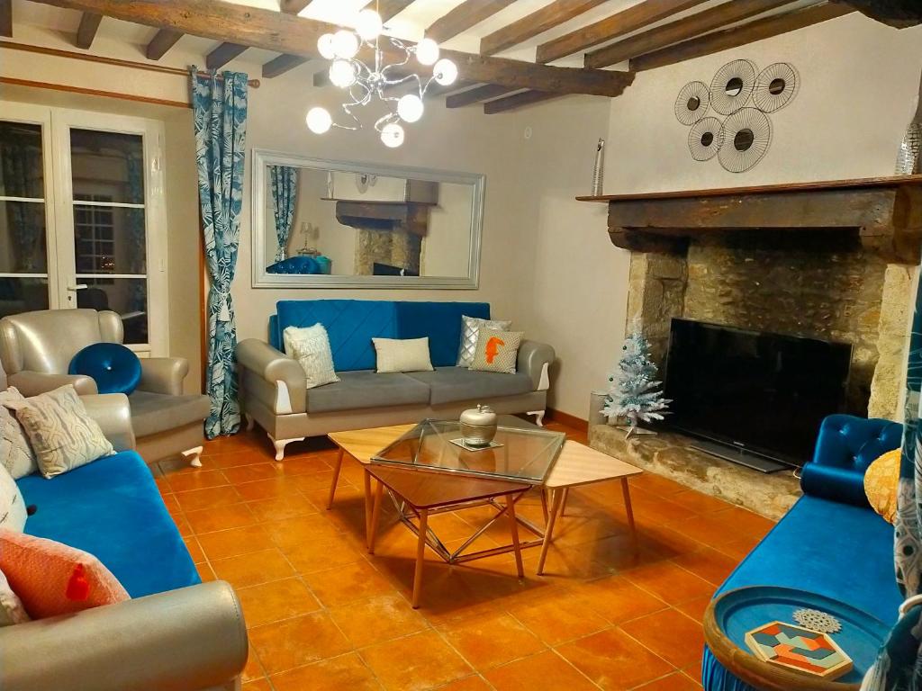 a living room with a couch and a fireplace at Gîte Eloquent in Gratot